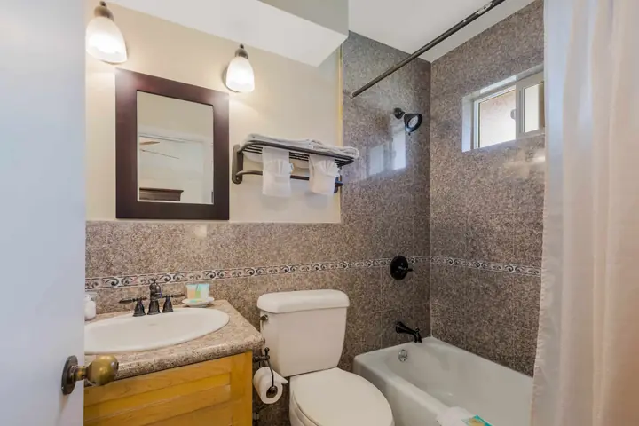 Bathroom with a bathtub and shower, a granite vanity and a towel rack