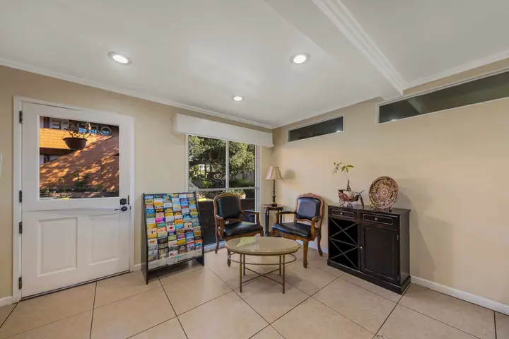 Lobby seating area with two carved armchairs, a round table and a rack of local brochures